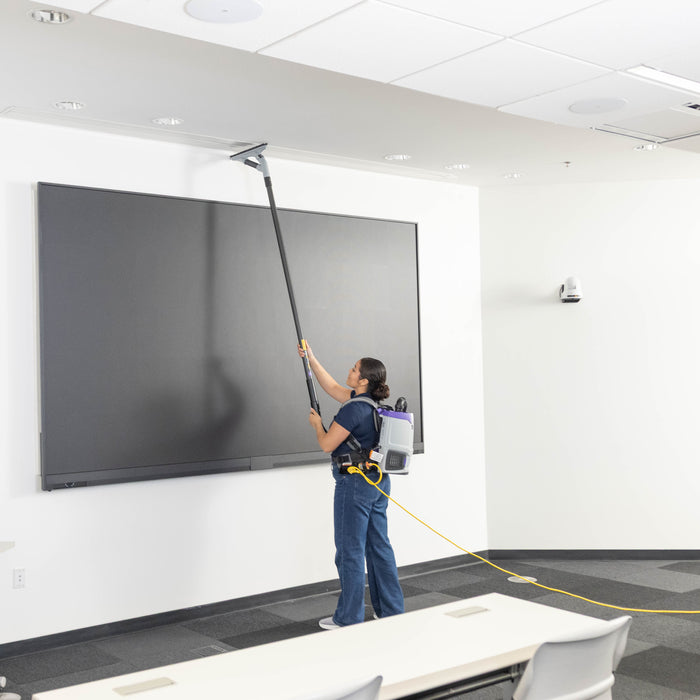 Cleaning the top of a wall display with the GoHigh ProBlade from the floor