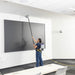Cleaning the top of a wall display with the GoHigh ProBlade from the floor